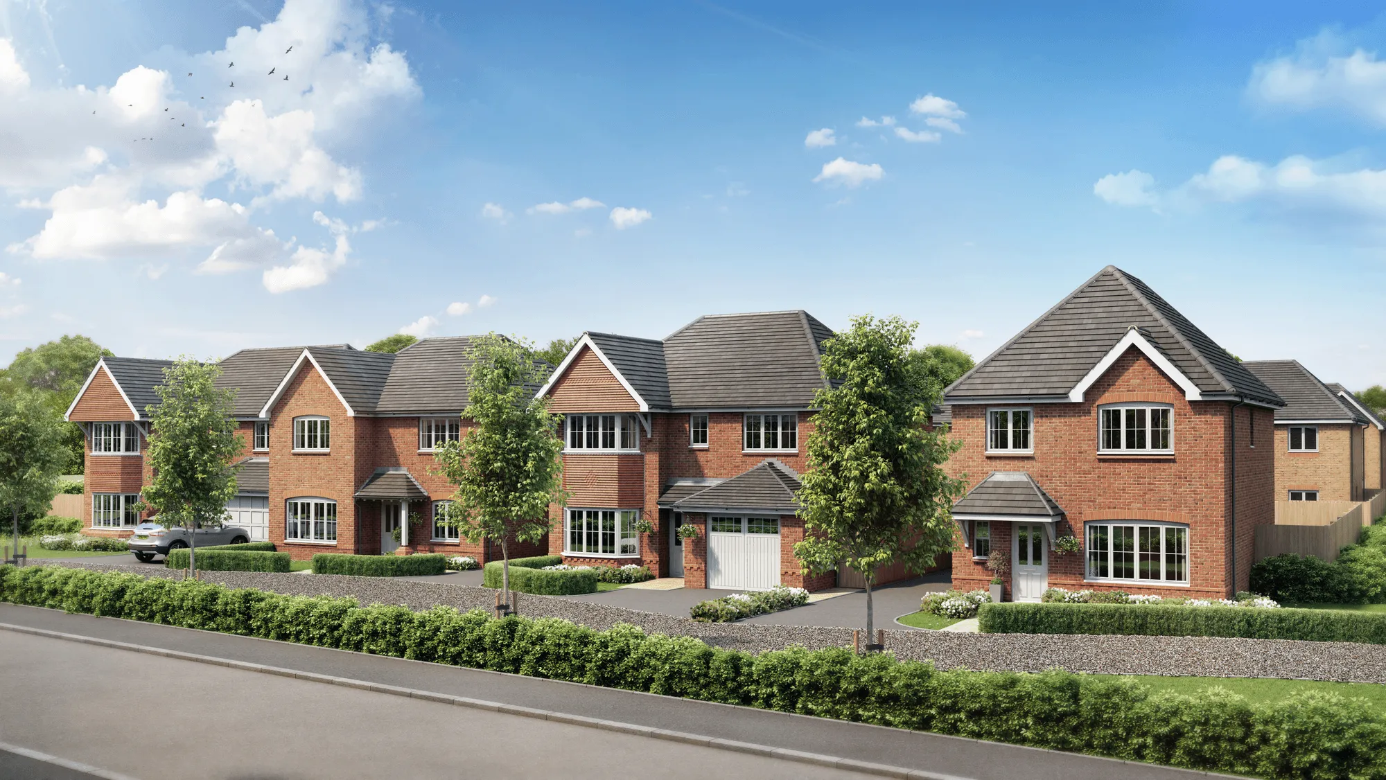 A row of new build homes by Anwyl Homes features red brick exteriors, slate roofs, well-maintained gardens, and a spacious, tranquil street view under a bright blue sky.