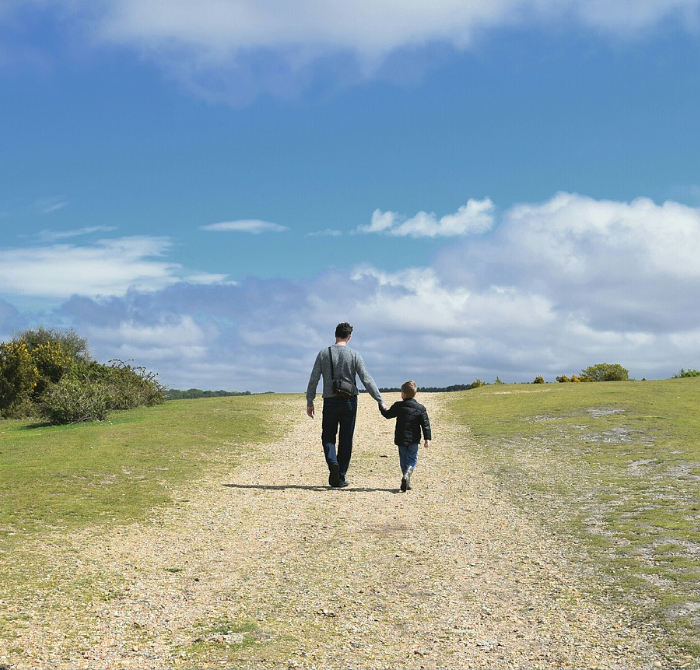 Father and son walking through open space 